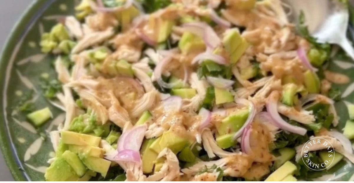 A colorful Chicken & Kale Salad featuring shredded chicken, cubed avocado, sliced red onion, chopped kale, and optional cucumbers and sweet potato, beautifully arranged in a bowl.