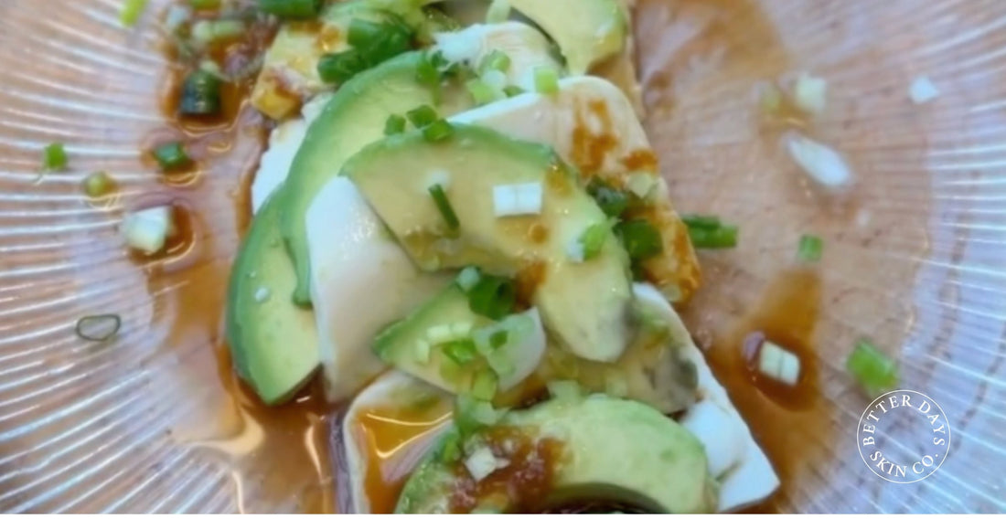 A vibrant plate of creamy avocado and tofu, garnished with ginger, spring onions, and a drizzle of soy sauce, showcasing a colorful and nutritious meal.