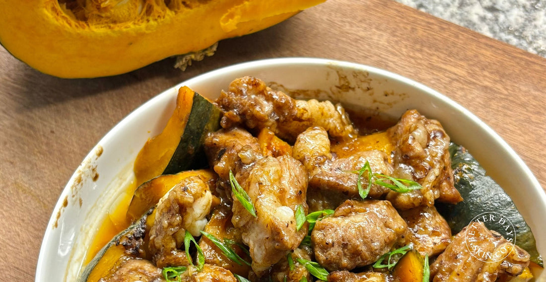 A vibrant bowl of Steamed Pork Ribs with Pumpkin, showcasing tender pork ribs layered with bright orange pumpkin chunks.