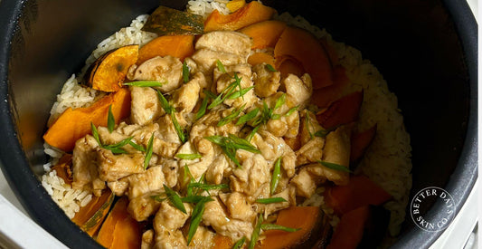 A vibrant bowl of Pumpkin Chicken Rice, featuring tender pieces of chicken and creamy kabocha pumpkin mixed with fluffy rice.