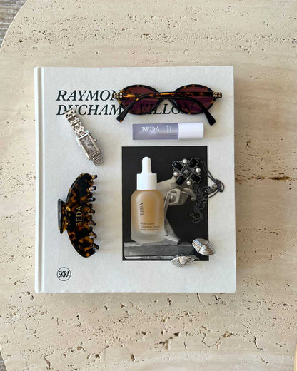 skincare, sunglasses, jewelry on coffee table book aesthetic